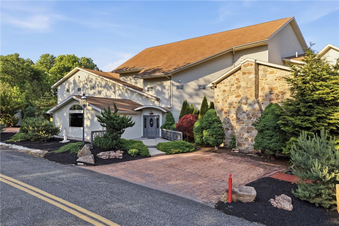 Image 2: An inviting entry with a paver driveway leads to t
