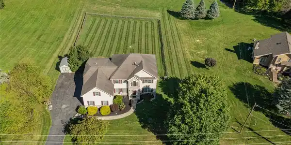 Image 3: An expansive green lawn surrounds this multi-level