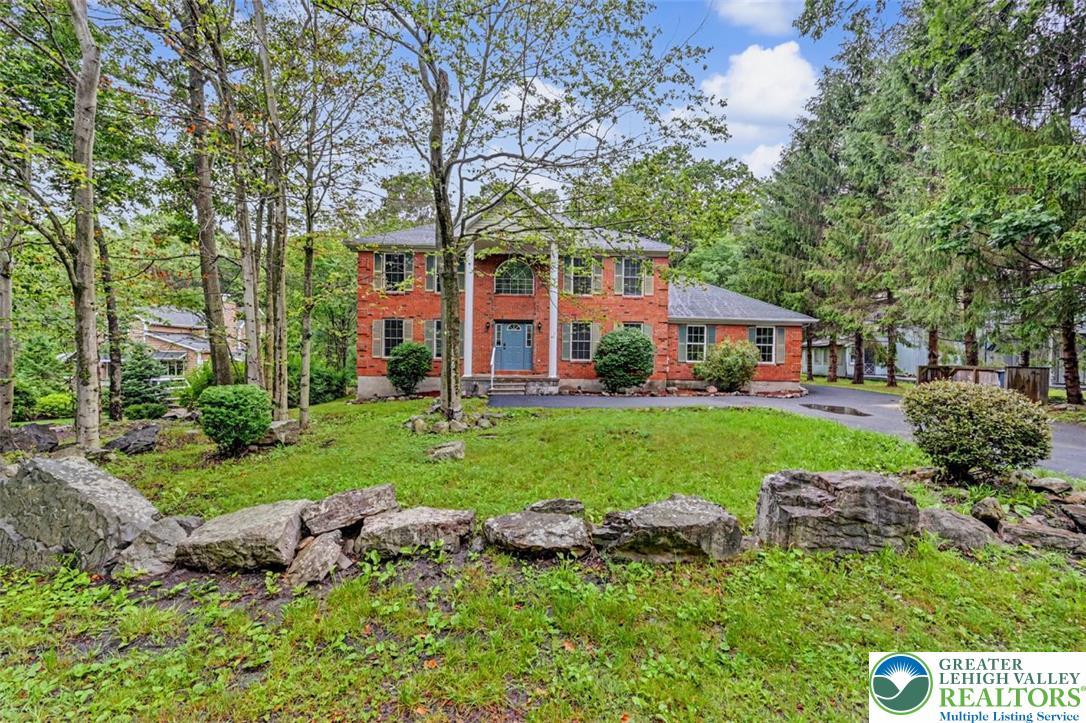 Image 3: Colonial Home Street View. A stately brick home si