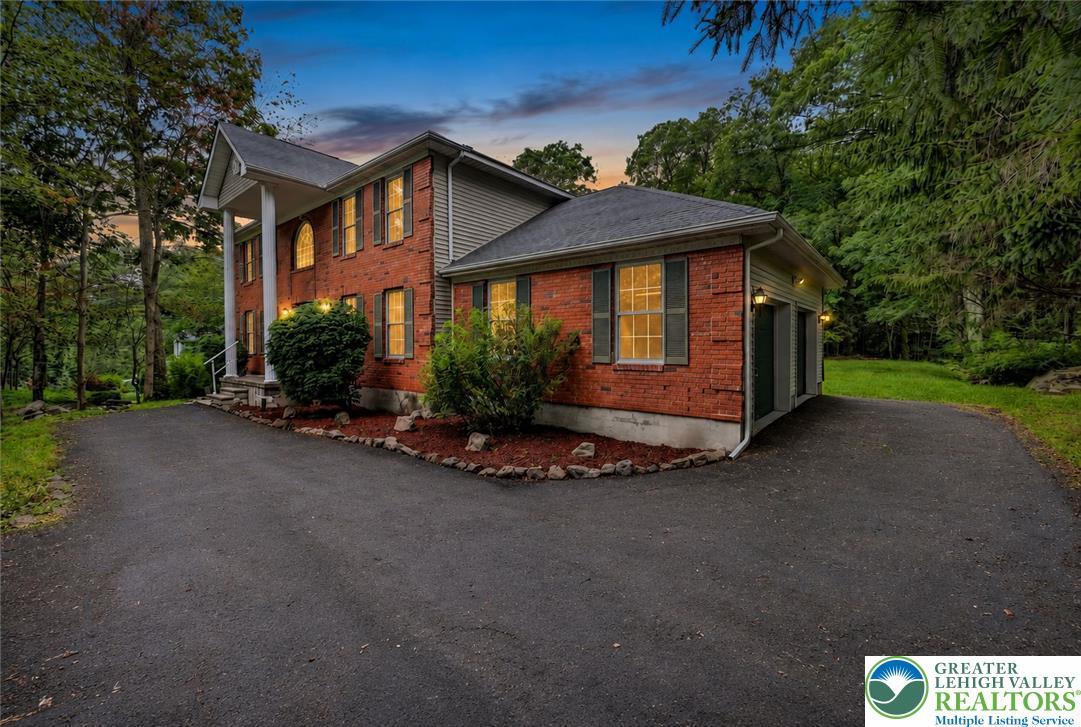 Image 4: Spacious Paved Driveway. Brick facade with strikin