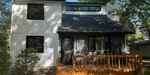 Image 2: Modern facade with a newly stained deck invites yo