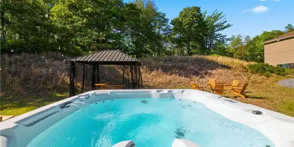 Image 2: A sparkling outdoor spa beckons, framed by a charm