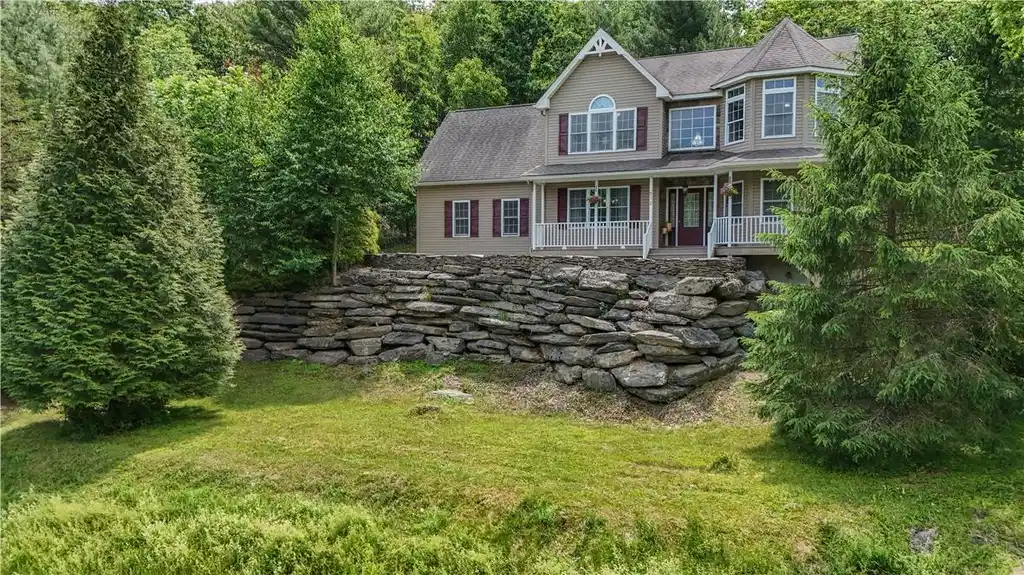 Image 1: Perched on a verdant hillside, this residence offe