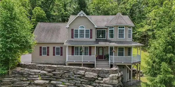 Image 2: A charming home nestled amongst green trees with a