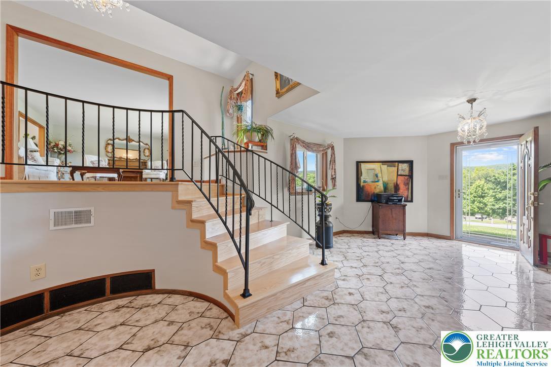 Image 3: A split-level entry features sleek tile flooring,