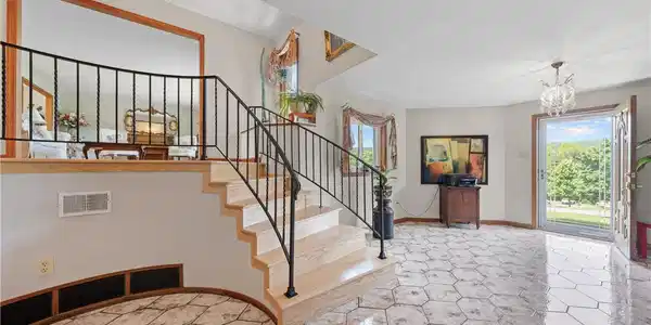Image 3: A split-level entry features sleek tile flooring,