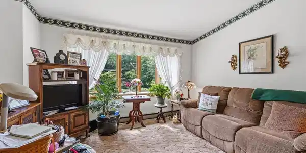 Image 3: A comfortable living area features plush carpeting