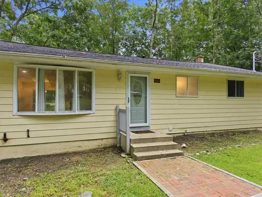 Image 1: Wooded surroundings frame a classic single-story e
