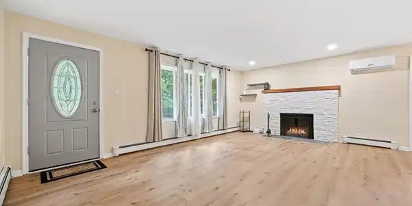 Image 4: Rich wood-look flooring and a white-brick fireplac