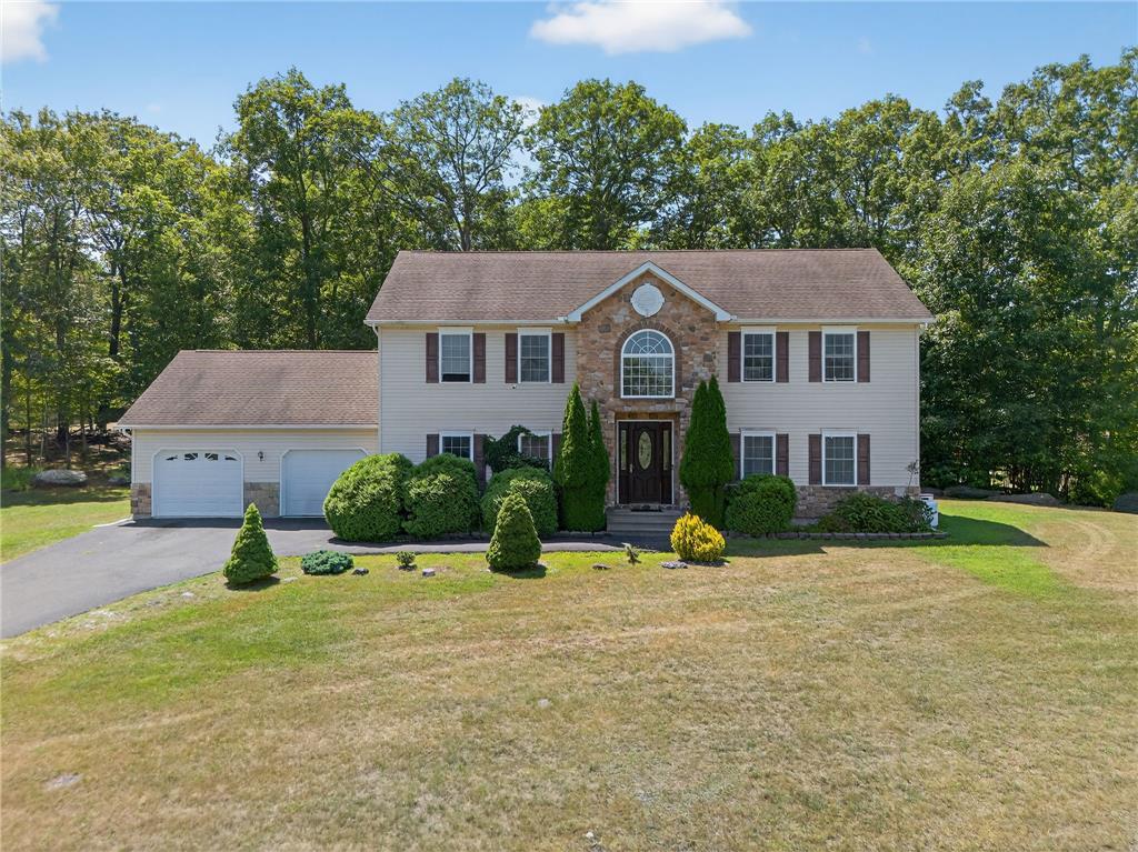 Image 1: A spacious home with stone accents and a two-car g