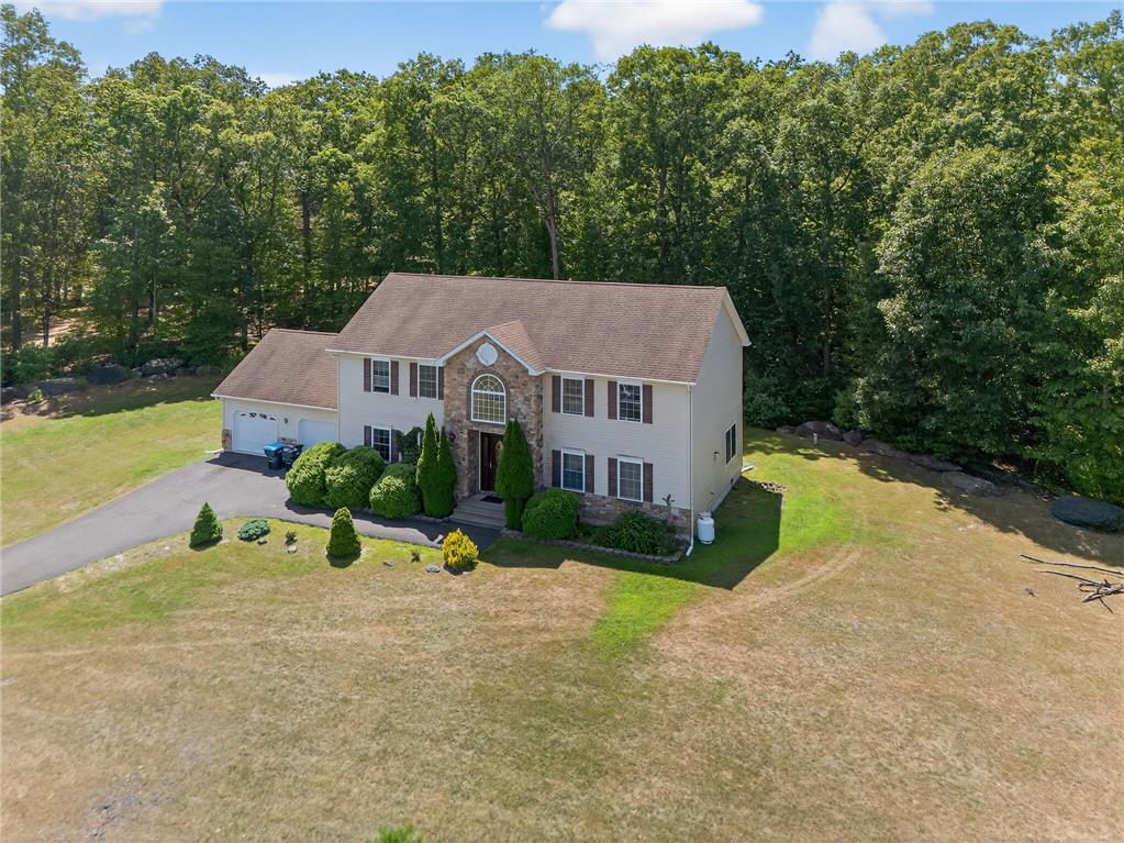 Image 2: Perched on a verdant lot, this residence offers a
