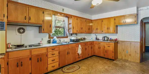 Image 3: Rich wood cabinetry wraps around this kitchen feat