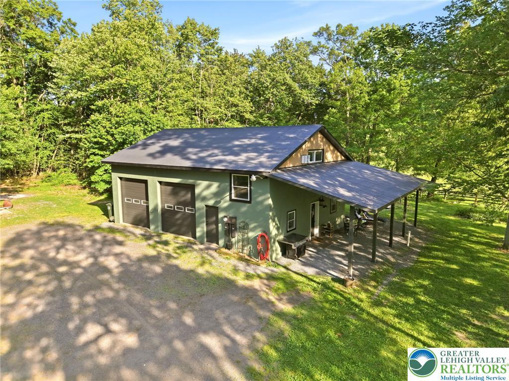 Image 2: Green siding and a metal roof complement this home