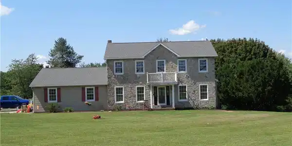 Image 2: A classic stone facade with matching siding border