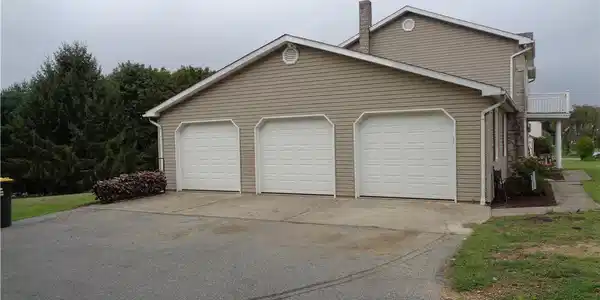 Image 3: A spacious driveway leads to three garage bays att