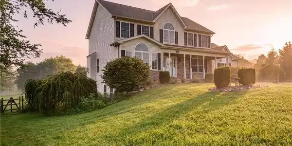 Image 3: Sloping green lawns lead to a classic two-story ho