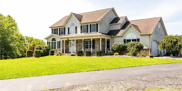 Image 4: An inviting paved driveway leads past a manicured