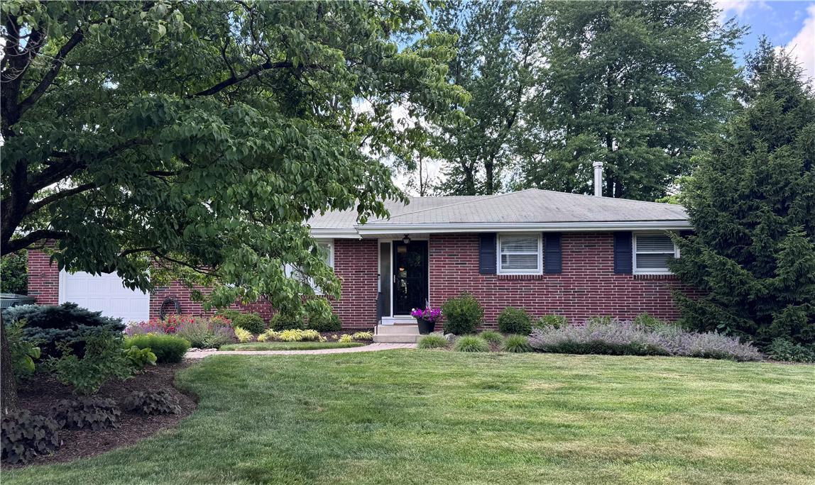 Image 2: Well-maintained brick residence with a neatly mani