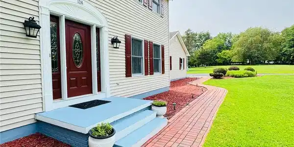 Image 2: A welcoming brick pathway leads to a classic two-s