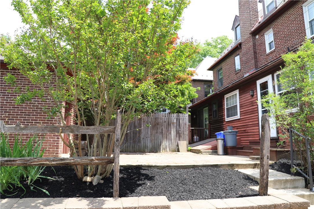 Image 3: A quaint backyard with brick and wood siding offer