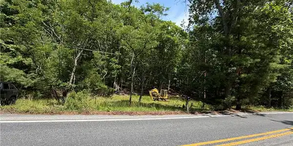 Image 2: A spacious, tree-lined lot offers an ideal foundat