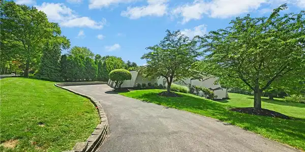Image 4: A gently curving asphalt driveway leads to a priva