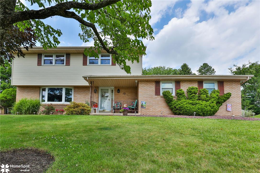 Image 3: A classic brick and siding home with a welcoming c