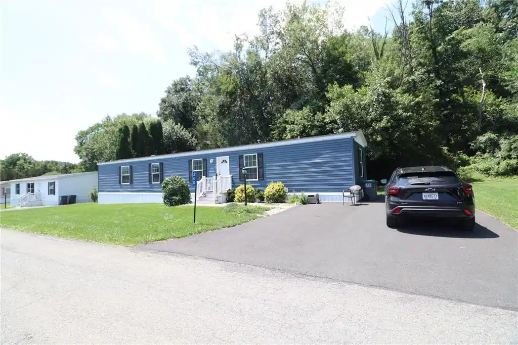 Image 1: A well-maintained manufactured home nestled amidst