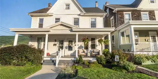 Image 2: A classic front porch and well-maintained landscap