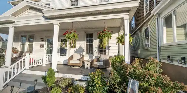 Image 4: A welcoming front porch, shaded by a broad roof, c