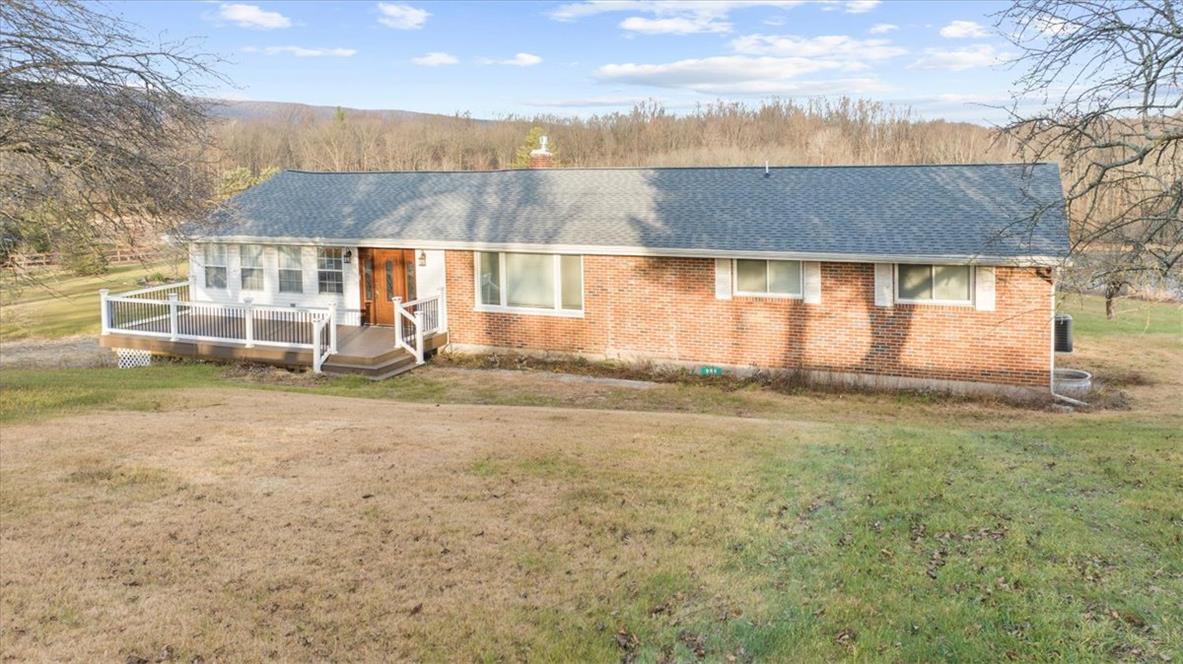 Image 1: A charming brick exterior with a welcoming deck an
