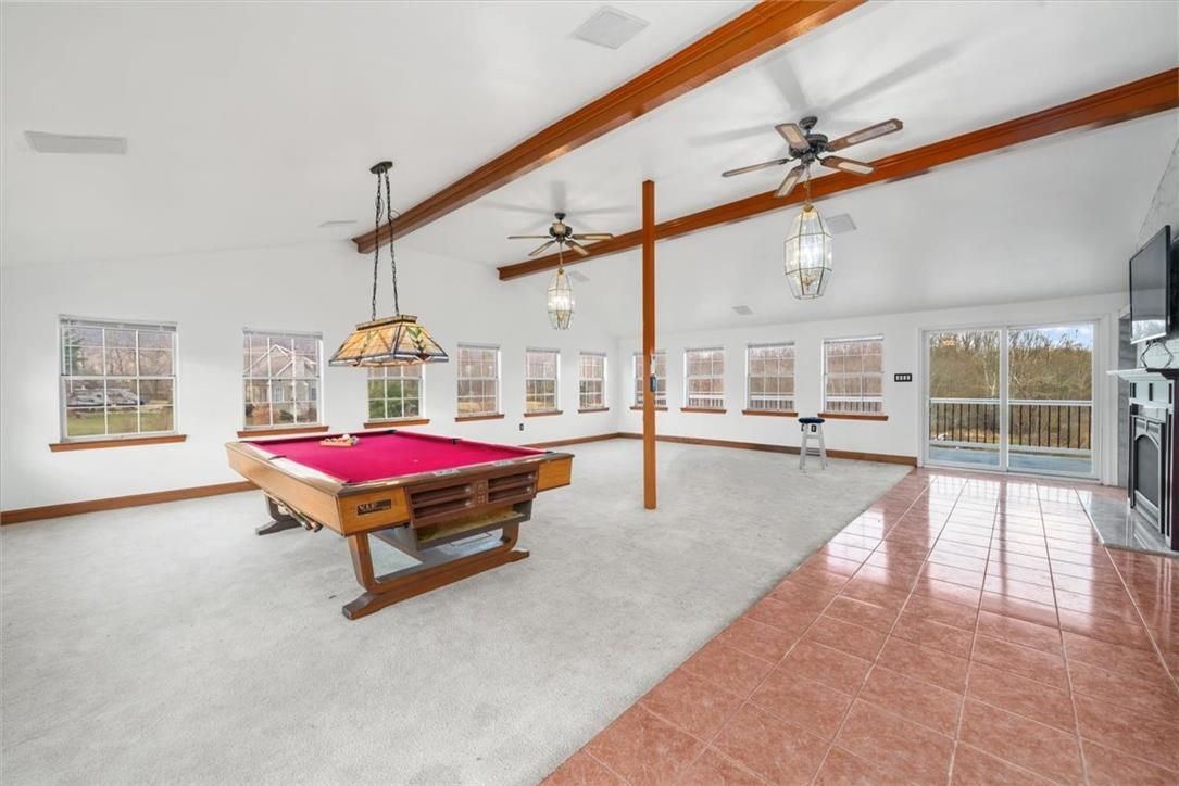 Image 4: A spacious recreation room featuring high ceilings