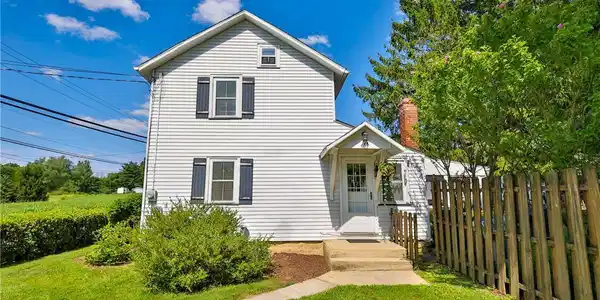 Image 2: A classic two-story residence with white siding an