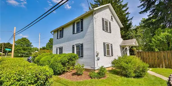 Image 4: A classic two-story residence with white siding an