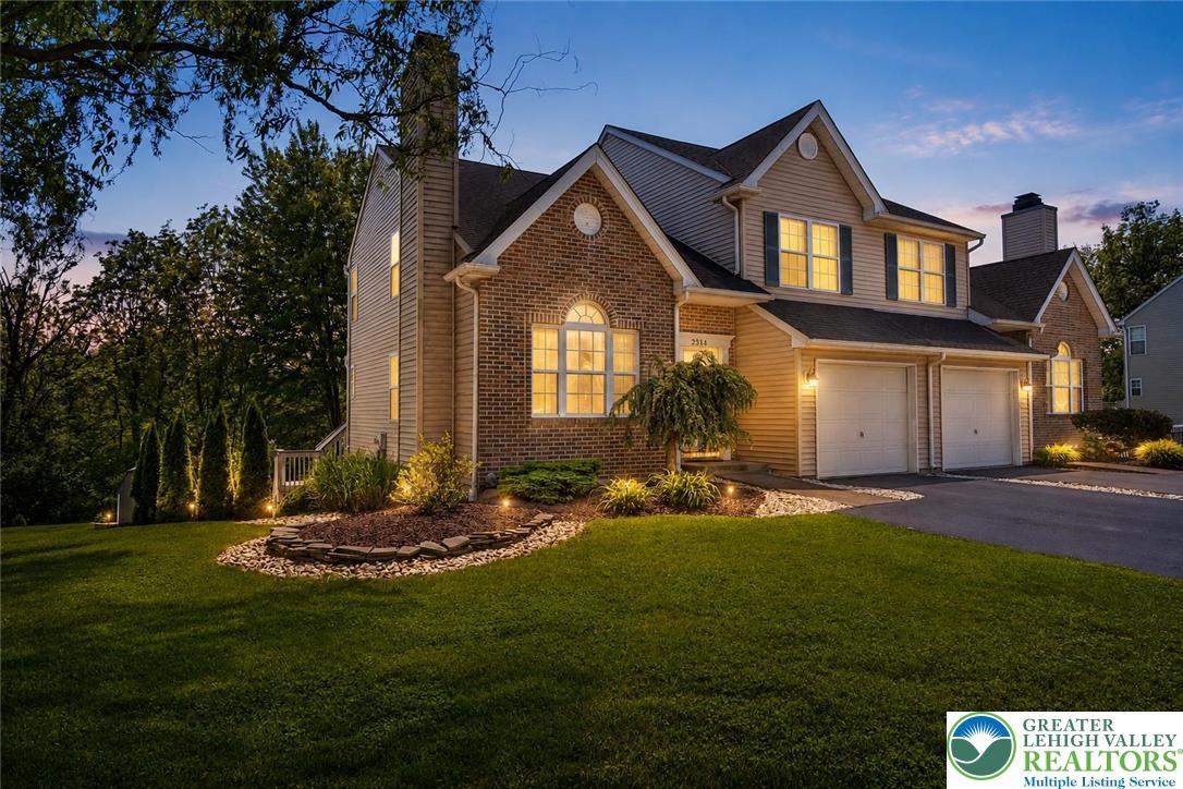 Image 2: Illuminated by dusk, this home boasts charming bri