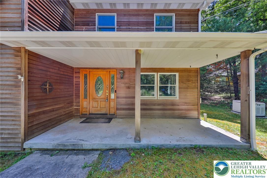 Image 4: A welcoming front porch features a wood entry door