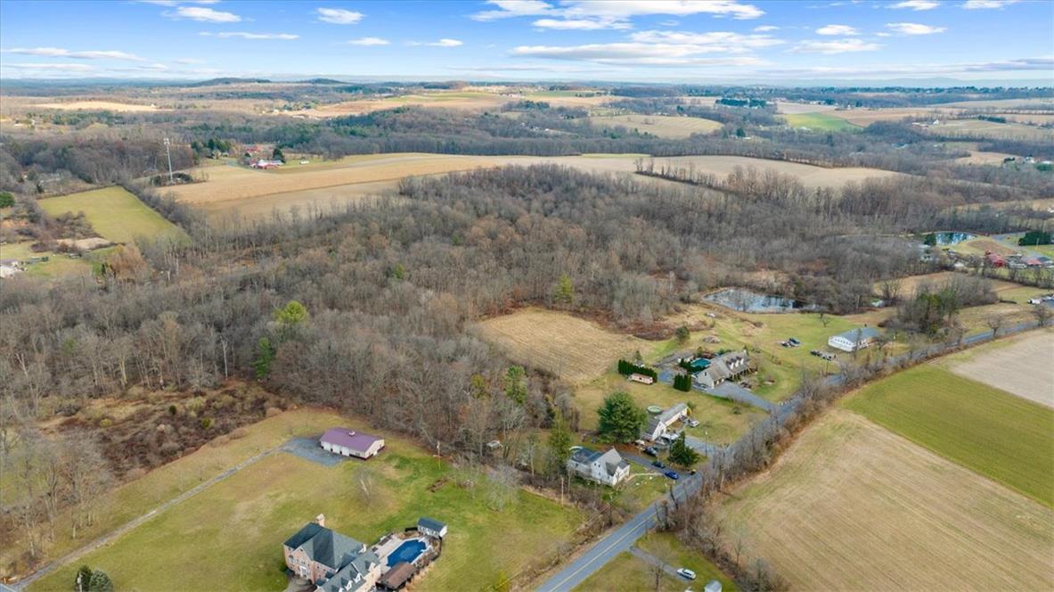 Image 4: Sprawling rural acreage with homes, woodland, and