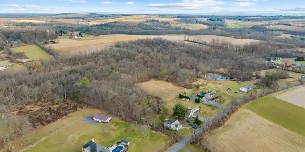 Image 4: Sprawling rural acreage with homes, woodland, and
