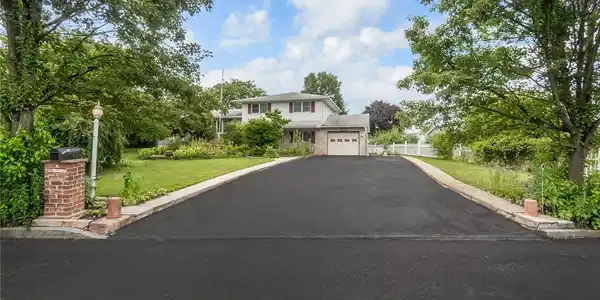 Image 3: A neatly paved driveway leads to this charming hom