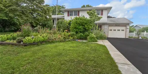 Image 4: A split-level home with a lush garden bed and atta