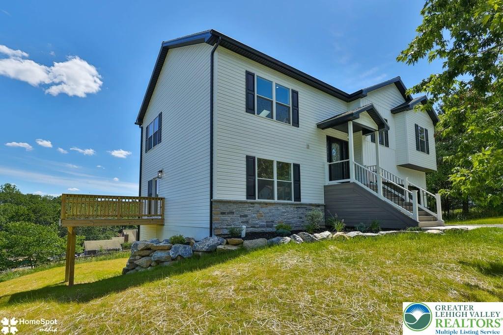 Image 2: Perched on a grassy hill, this charming two-story