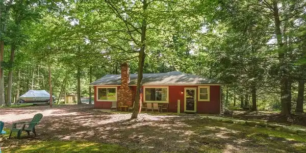 Image 3: A charming woodland retreat, this cozy residence i