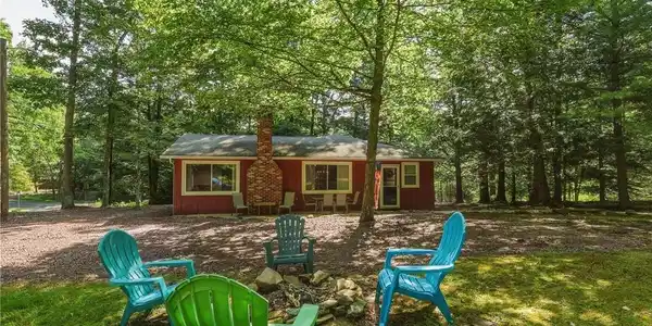 Image 4: Nestled in a verdant setting, this charming cabin