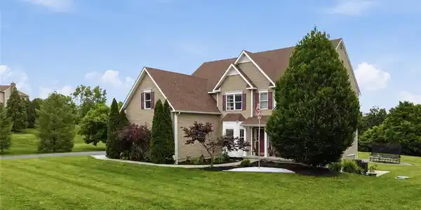 Image 4: A welcoming residence boasts a verdant front yard