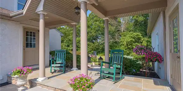 Image 3: A welcoming covered porch with sturdy columns offe