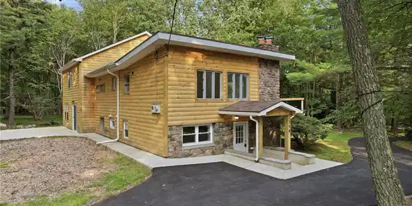Image 3: A charming wood-sided residence, accented with nat