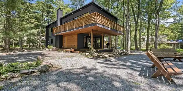 Image 3: Modern retreat nestled in a wooded setting, offeri