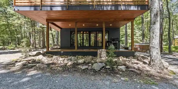 Image 4: Modern retreat nestled amongst trees, featuring a