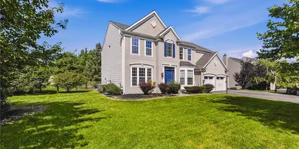 Image 2: A spacious green lawn frames this stately two-stor