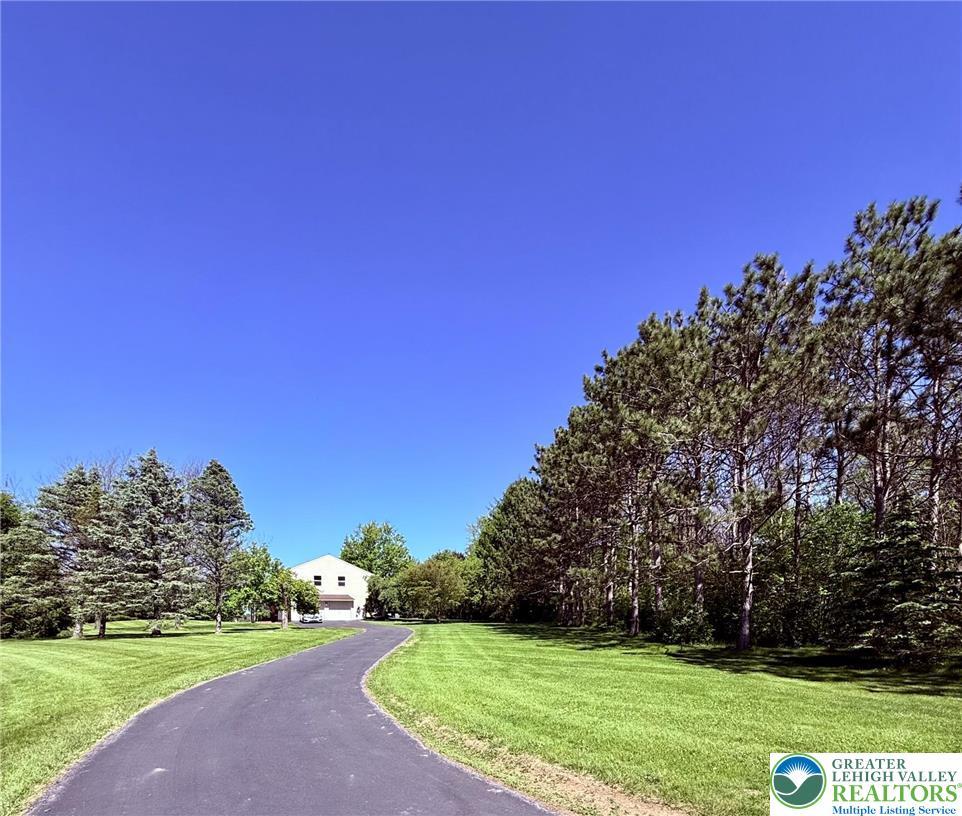 Image 3: A long paved driveway leads to a classic home nest